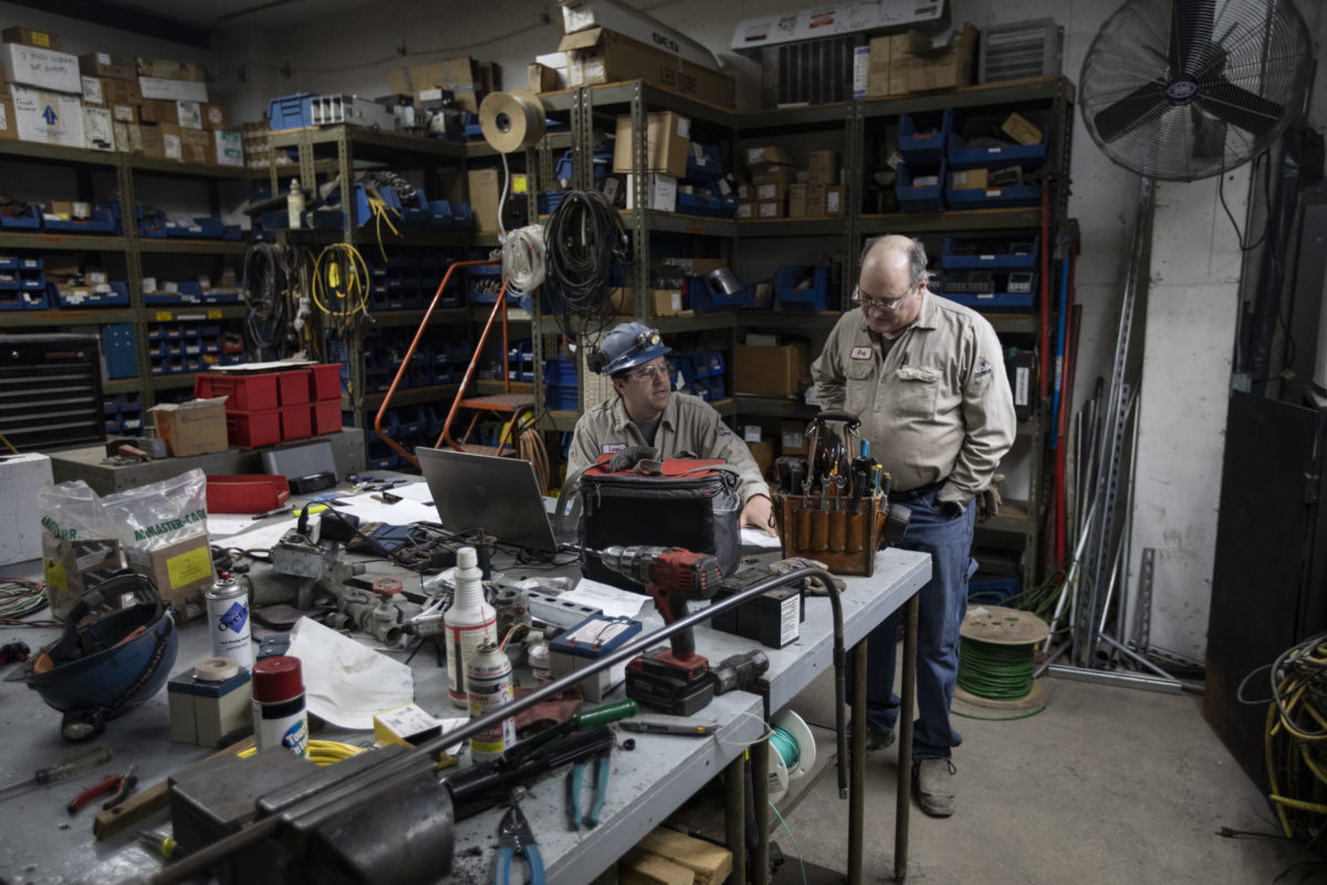 Two employees working at a table in the workshop.